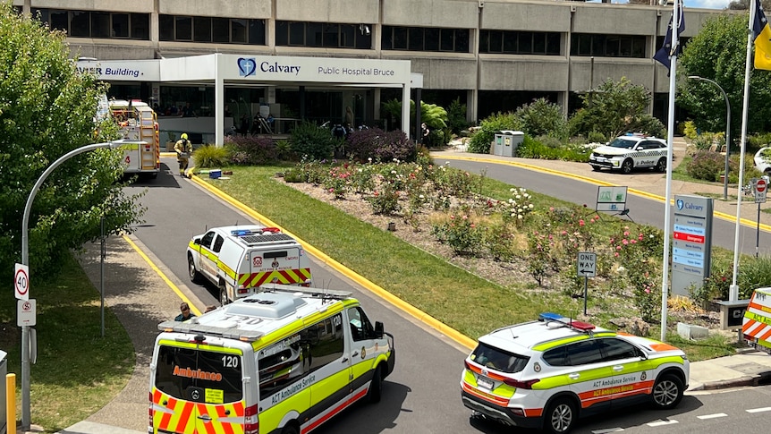 Three emergency vehicles outside a hospital.