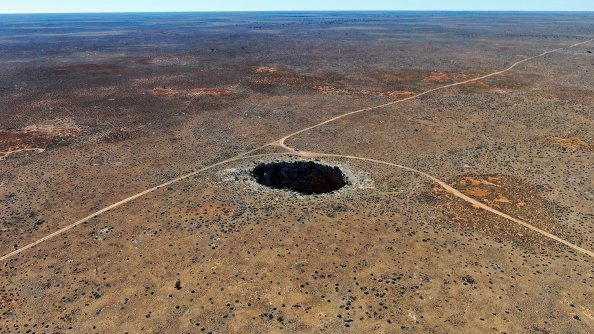 A giant hole in a dry barren landscape. 