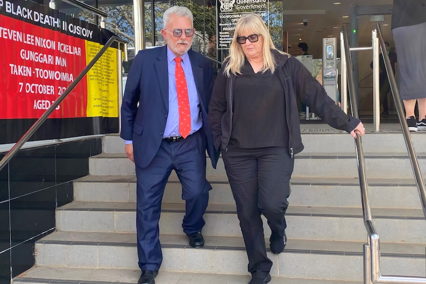 man and woman walk down steps outside the Toowoomba Courthouse