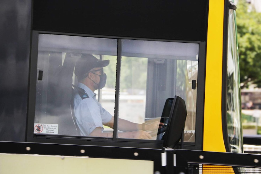 Un chauffeur de bus porte un masque en conduisant sur Southbank dans le centre-ville de Brisbane.