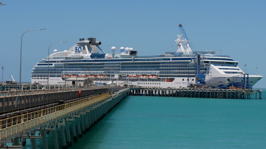 Image of a cruise ship docked at the end of a jetty in northern Australia.