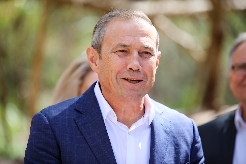 A head and shoulders shot of WA Deputy Premier Roger Cook dressed in a suit speaking outdoors.