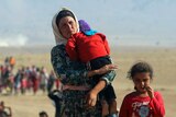Displaced Yazidis walk towards the Syrian border