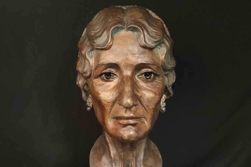 A bronze head of an older woman with short hair, looking serious