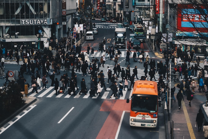 People wearing black suits crossing an intersection in Japan