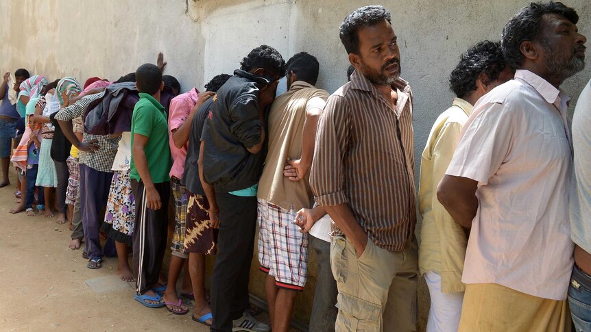 Sri Lankan asylum seekers sent back by Australia queue to enter the magistrate's court in Galle.