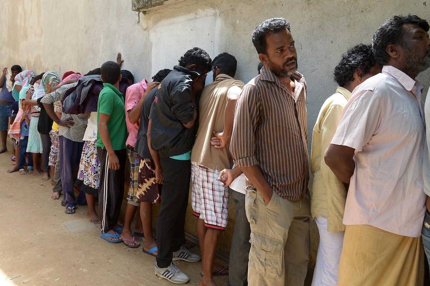 Sri Lankan asylum seekers sent back by Australia queue to enter the magistrate's court in Galle.