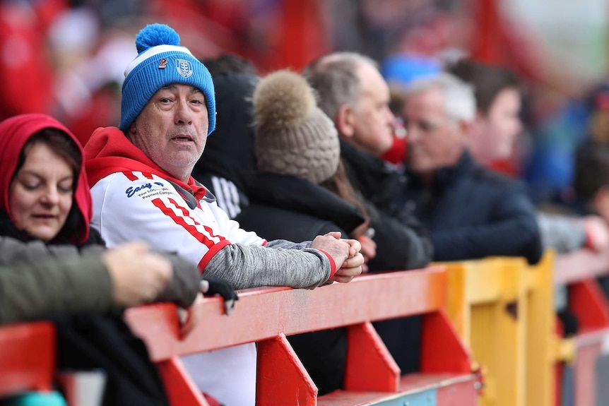 A man at a football match surrounded by others