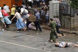 Nine dead: Japanese journalist Kenji Nagai lies wounded as police and soldiers charge protesters in Rangoon. Nagai later died in hospital.