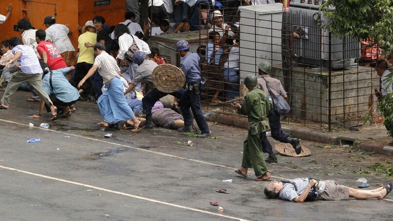 Among the dead: Japanese photographer Kenji Nagai lies injured (r) after police and military officials fired upon and then charged at protesters in Rangoon. Nagai later died.