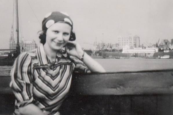 A black and white photo of a woman sitting overlooking the water
