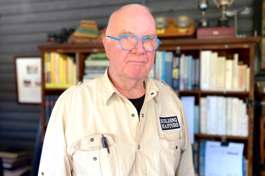 Mike Heathcote standing in front of a book shelf.