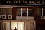 People look out from inside a quarantined hotel in Skopje, Macedonia