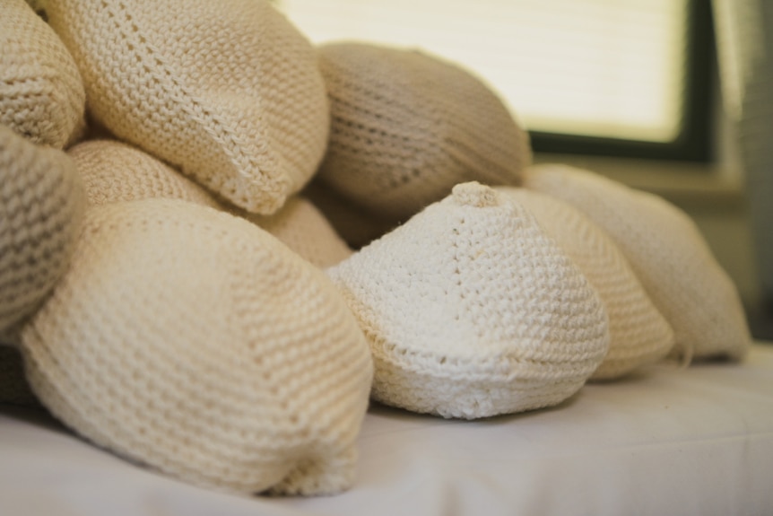 A stack of neutral-coloured knitted knockers 