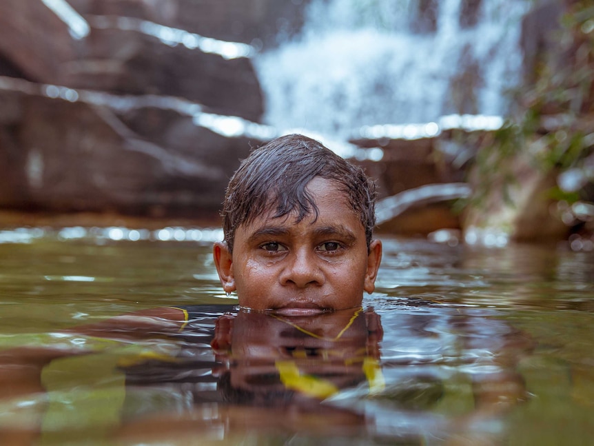 Junior Dirdi swims at little waterfall