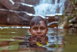 Junior Dirdi swims at little waterfall