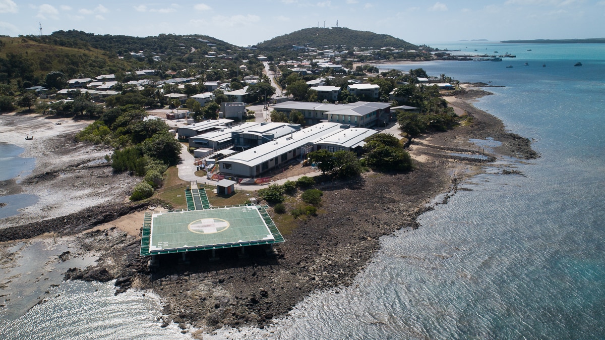 An aerial shot of a cluster of buildings near water.