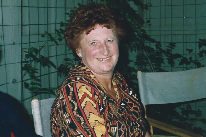 A photo from the 90s of a woman at a party smiling at the camera