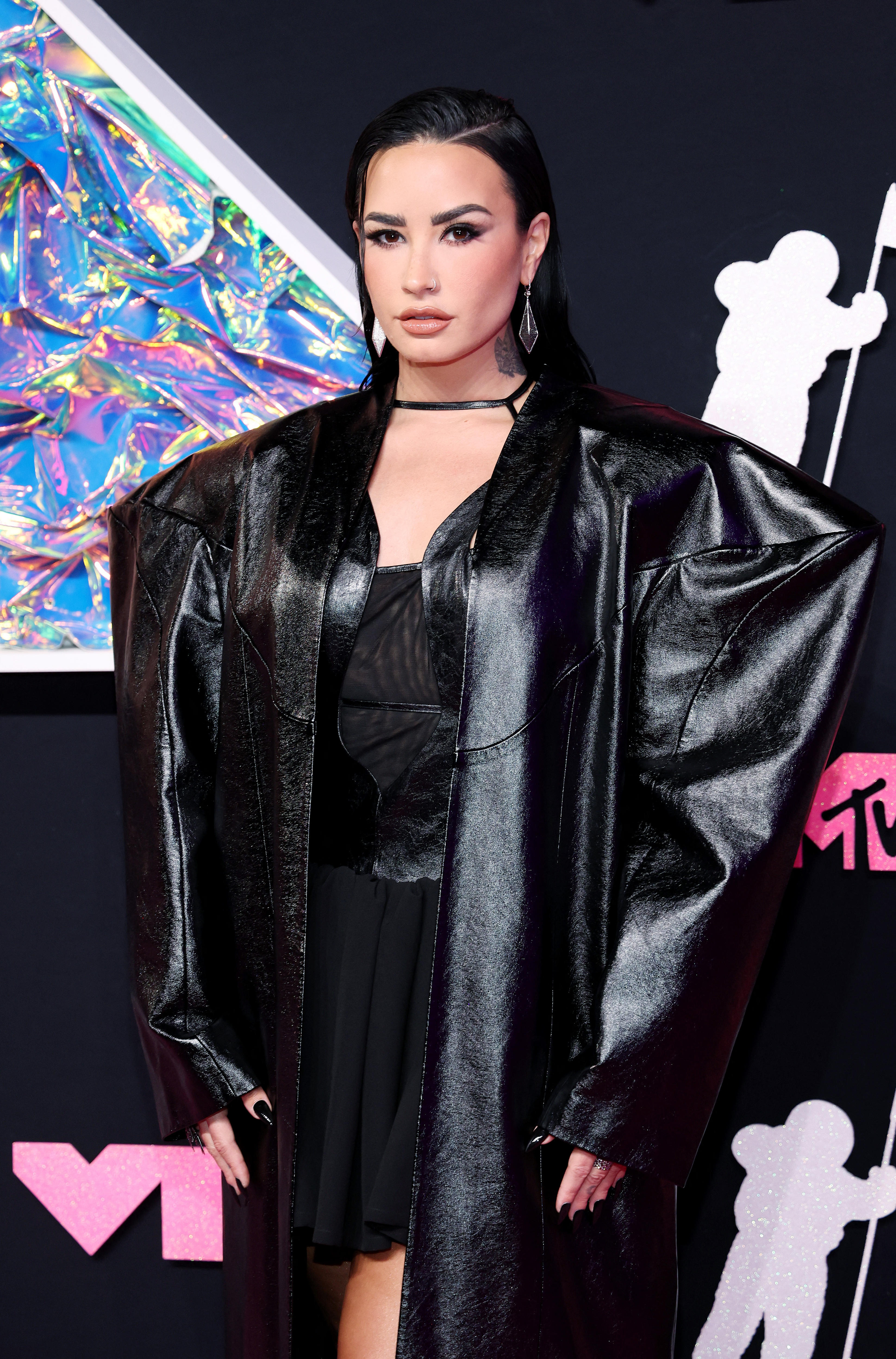 Demi Lovato wearing a black dress with big shoulder pads.