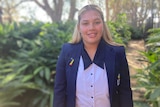 An Indigenous teenage girl in a blue school blazer and white top.