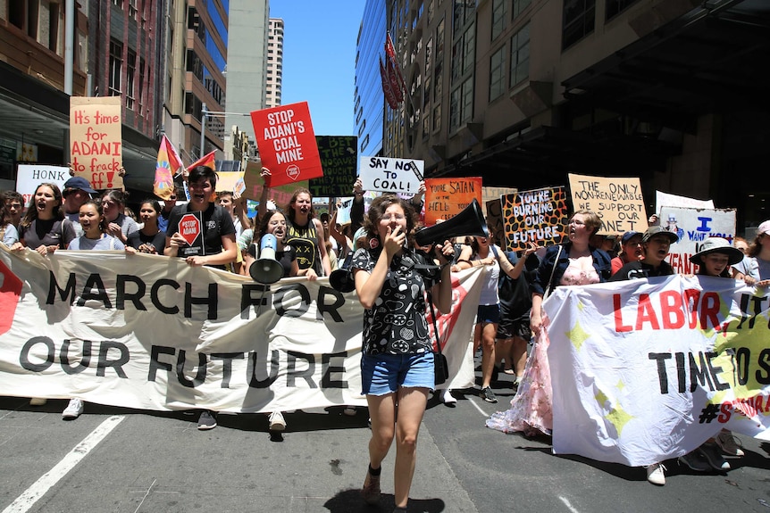 Young climate change protestors march through the street.