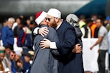 Two men hug at a memorial gathering after the Christchurch mosque attack.