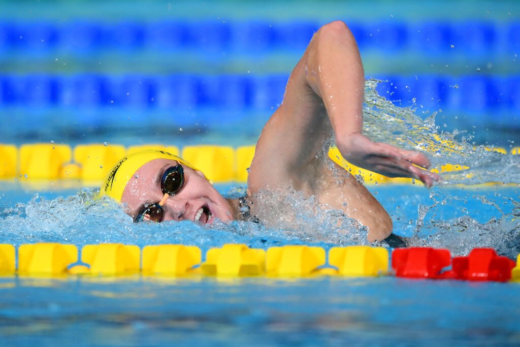ariarne titmus in action swimming freestyle wearing a yellow swimming cap