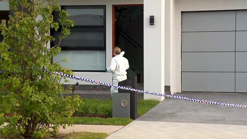 a forensic officer wearing a hazmat suit takes pictures at a mount druitt home after an alleged murder 