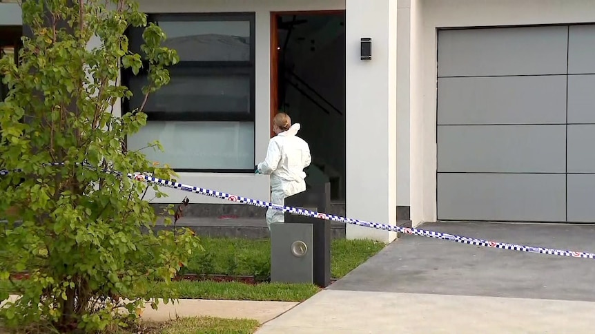 a forensic officer wearing a hazmat suit takes pictures at a mount druitt home after an alleged murder 