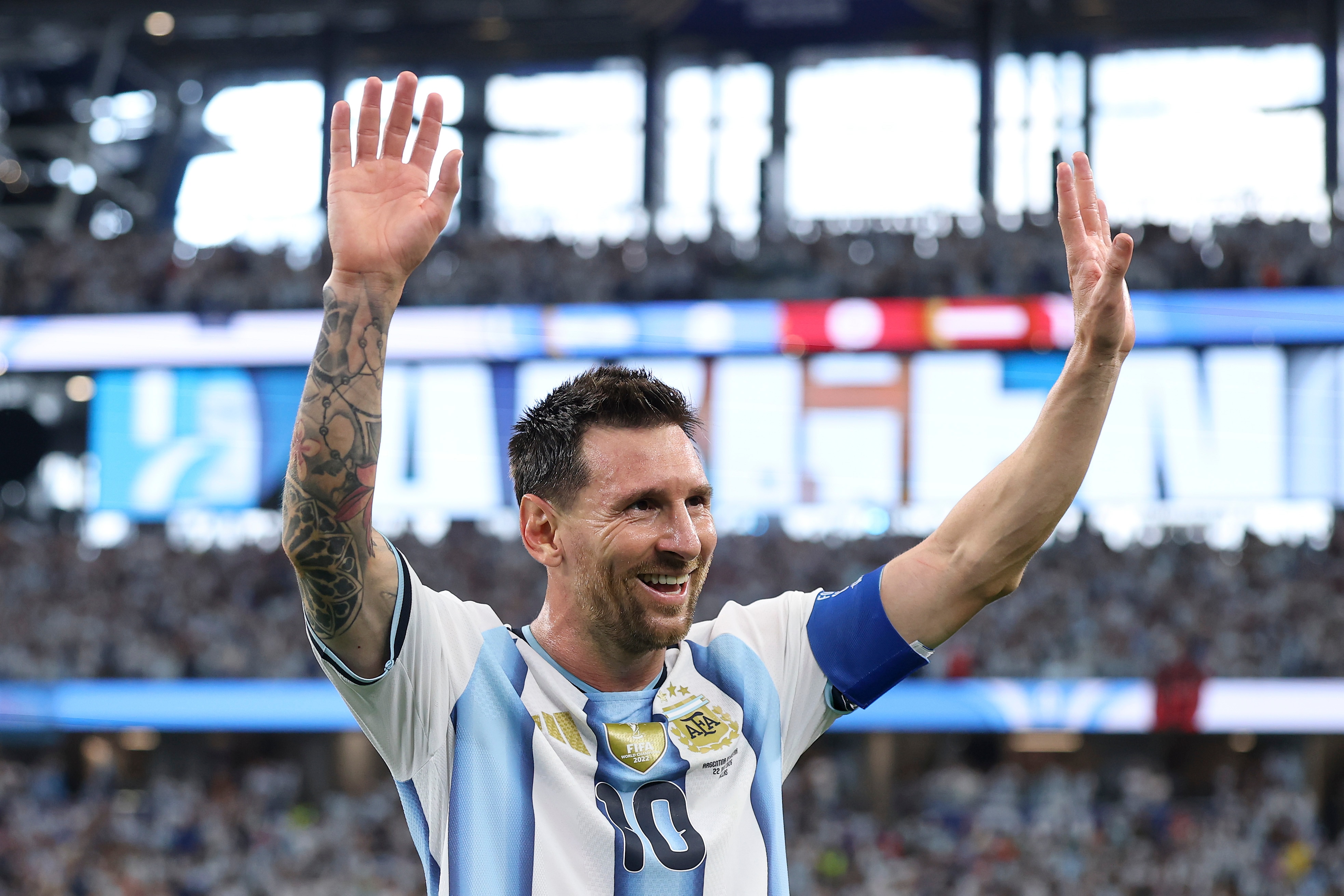 Lionel Messi holds his hands up and smiles