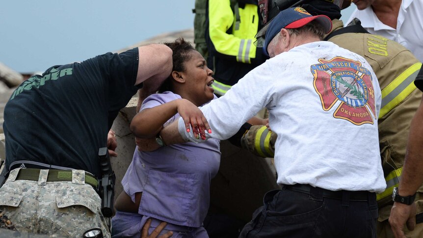 Rescue workers help free trapped tornado victim