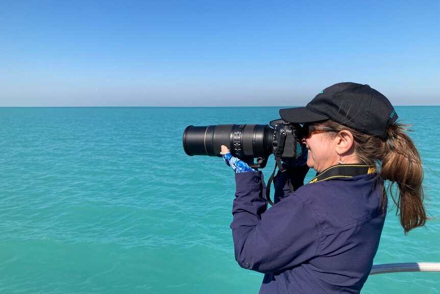 Dr Holly Raudino takes pictures on a boat in Roebuck Bay in Broome. 