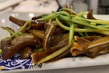 Plate of steaming braised pork and vegetables in dark soy sauce