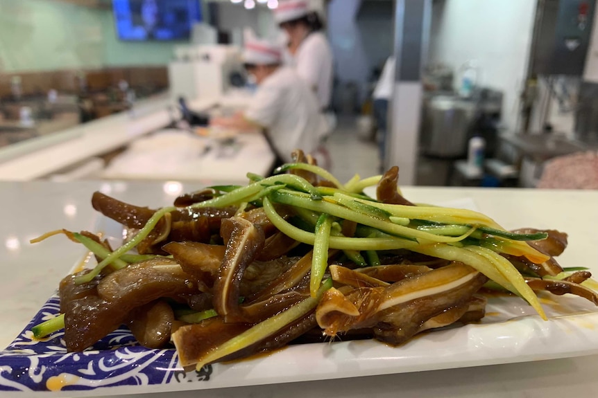 Plate of steaming braised pork and vegetables in dark soy sauce