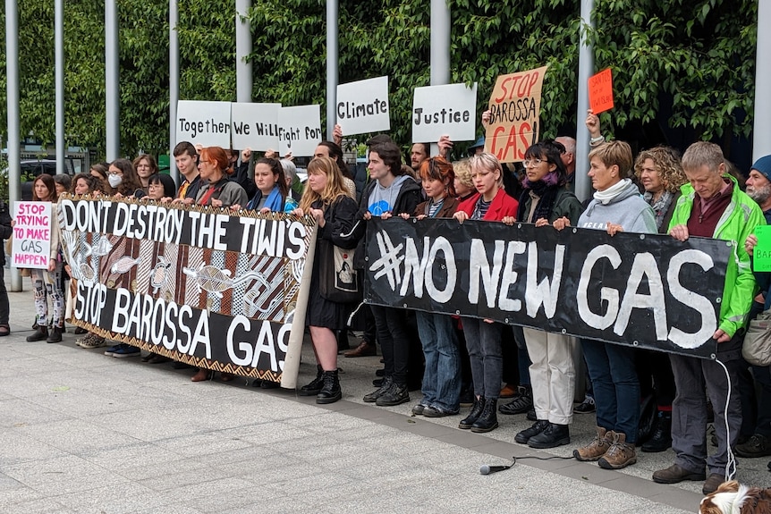 a group of protesters holding signs saying no new gas