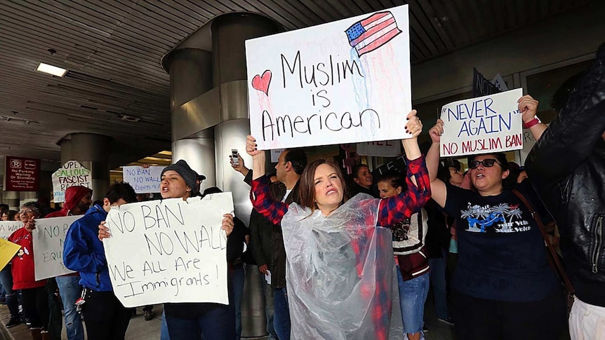 Protesters hold signs reading "Muslim is American" at Miami airport