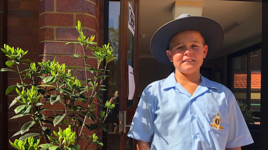 13-year-old William Johnson is dressed in his school uniform outside the boarding house