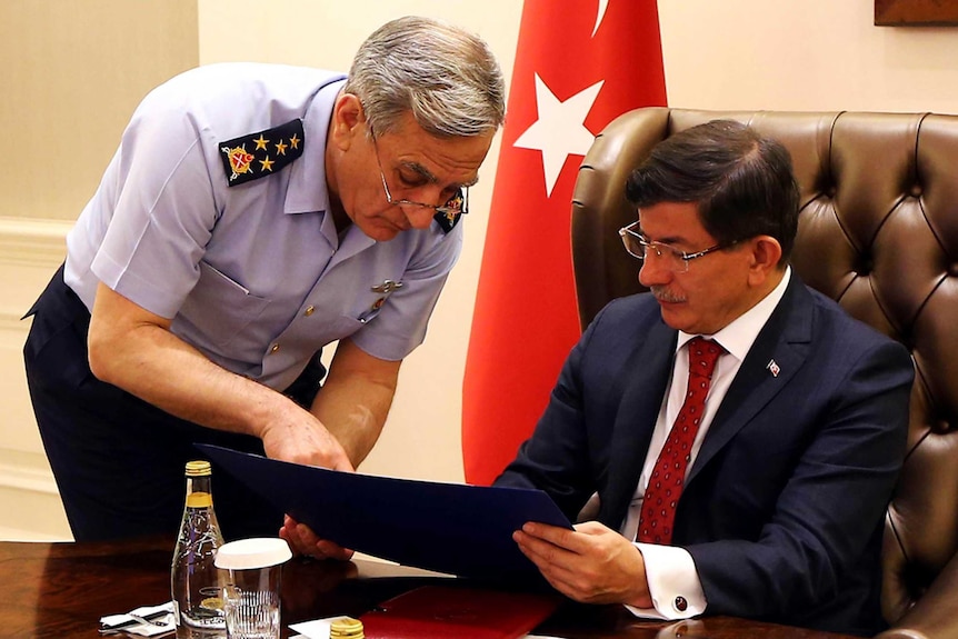 Turkey's prime minister Ahmet Davutoglu being briefed by General Akin Ozturk