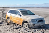 A silver car is bogged