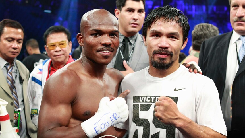 Manny Pacquiao and Timothy Bradley stand arm in arm in the ring after a fight.