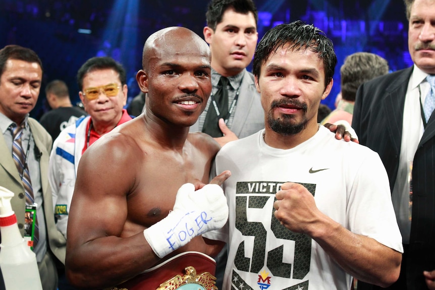 Manny Pacquiao and Timothy Bradley stand arm in arm in the ring after a fight.