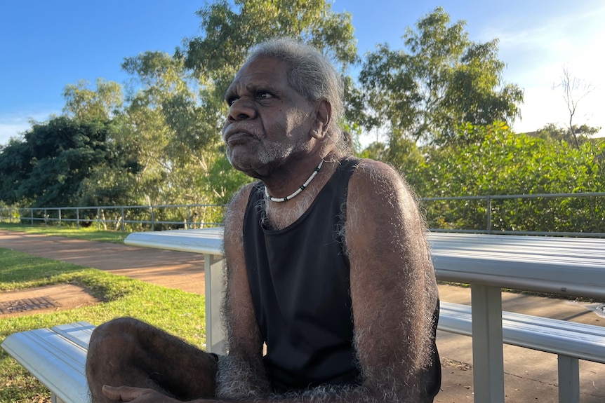 Kalkadoon man Jeffrey Doyle sits at a park bench next to the Leichhardt River. 