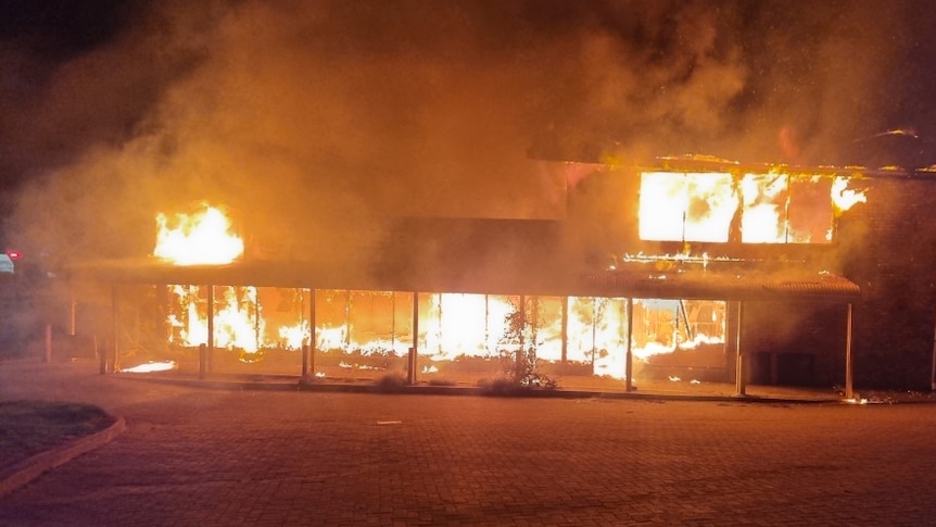 A building on fire with orange flames. 