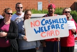 Protesters hold signs against the cashless welfare card in Ceduna in South Australia.