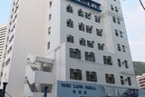 A white building approximately 20 storey's high with Wei Lun Hall logo.
