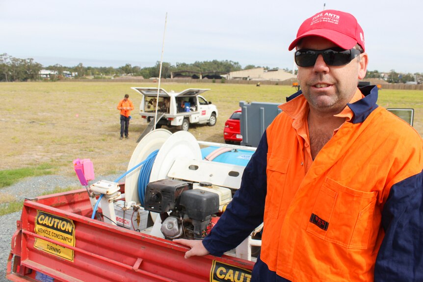 Gary Moreton stands with his equipment used to treat fire an nests.