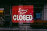 A red sign that says sorry we are closed
