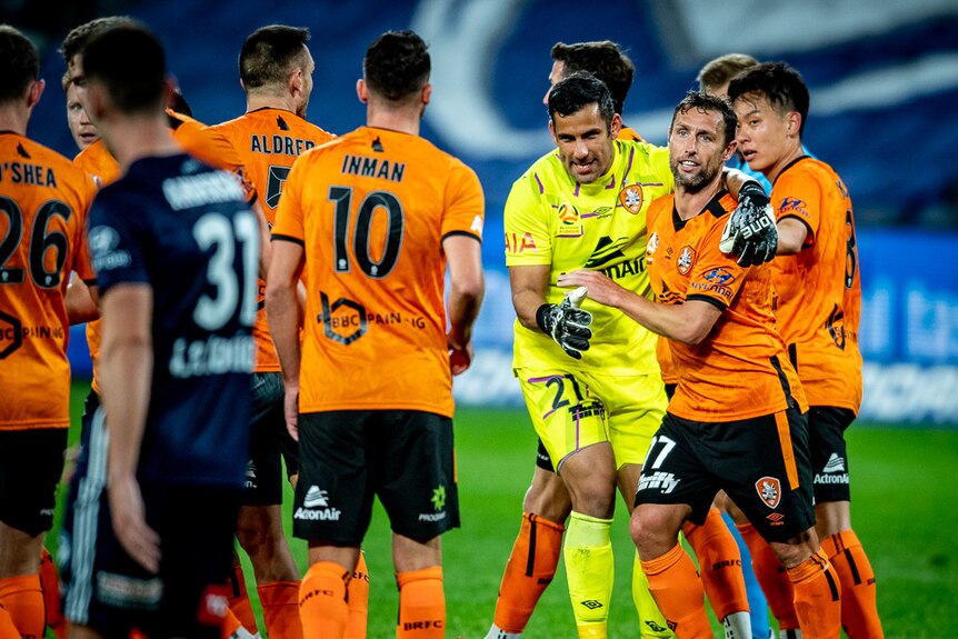 An A-League goalkeeper puts his arm around the team's striker who has just scored a goal.