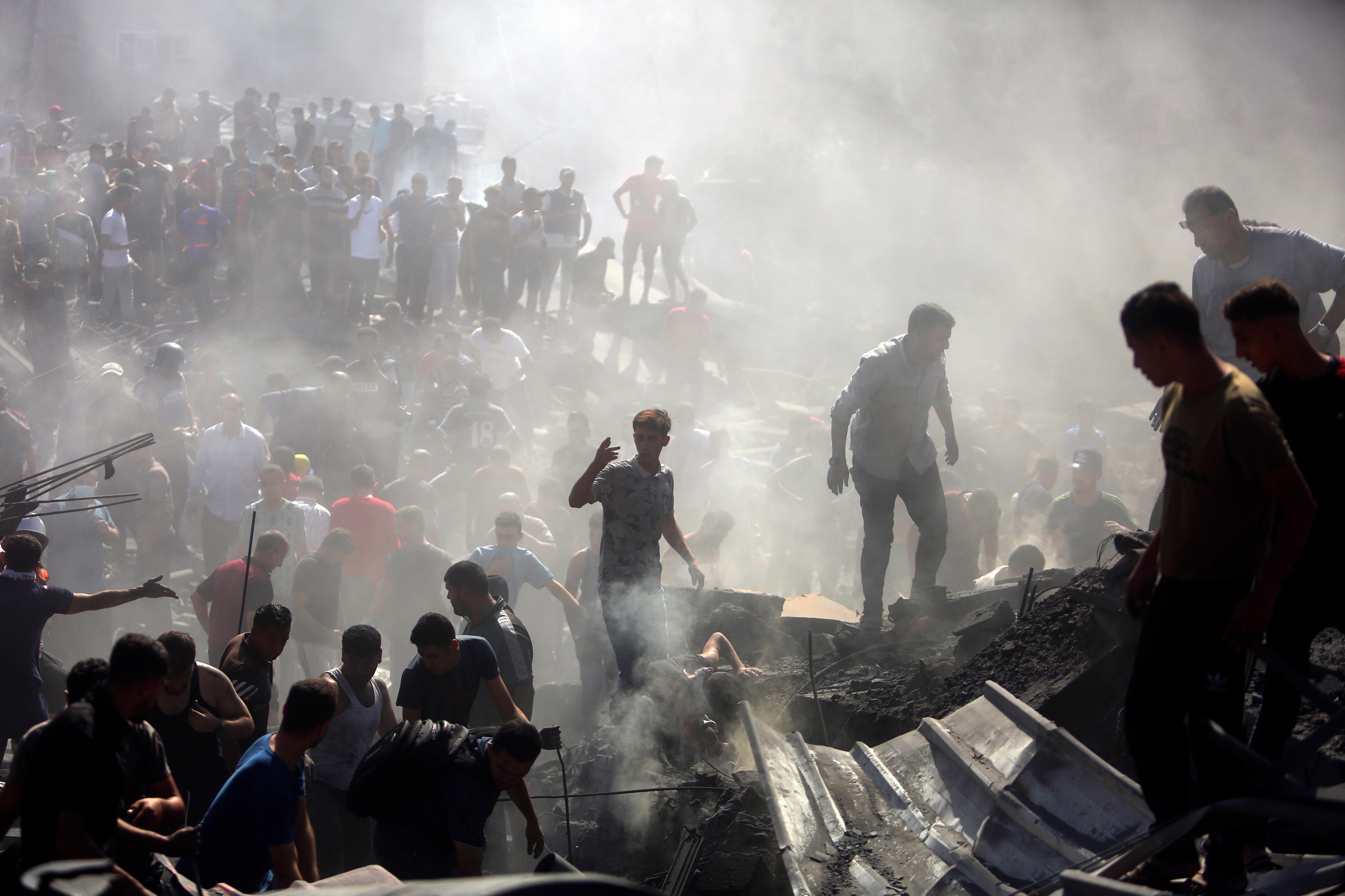 Palestinians inspect the rubble of destroyed buildings following Israeli airstrikes on the town of Khan Younis.
