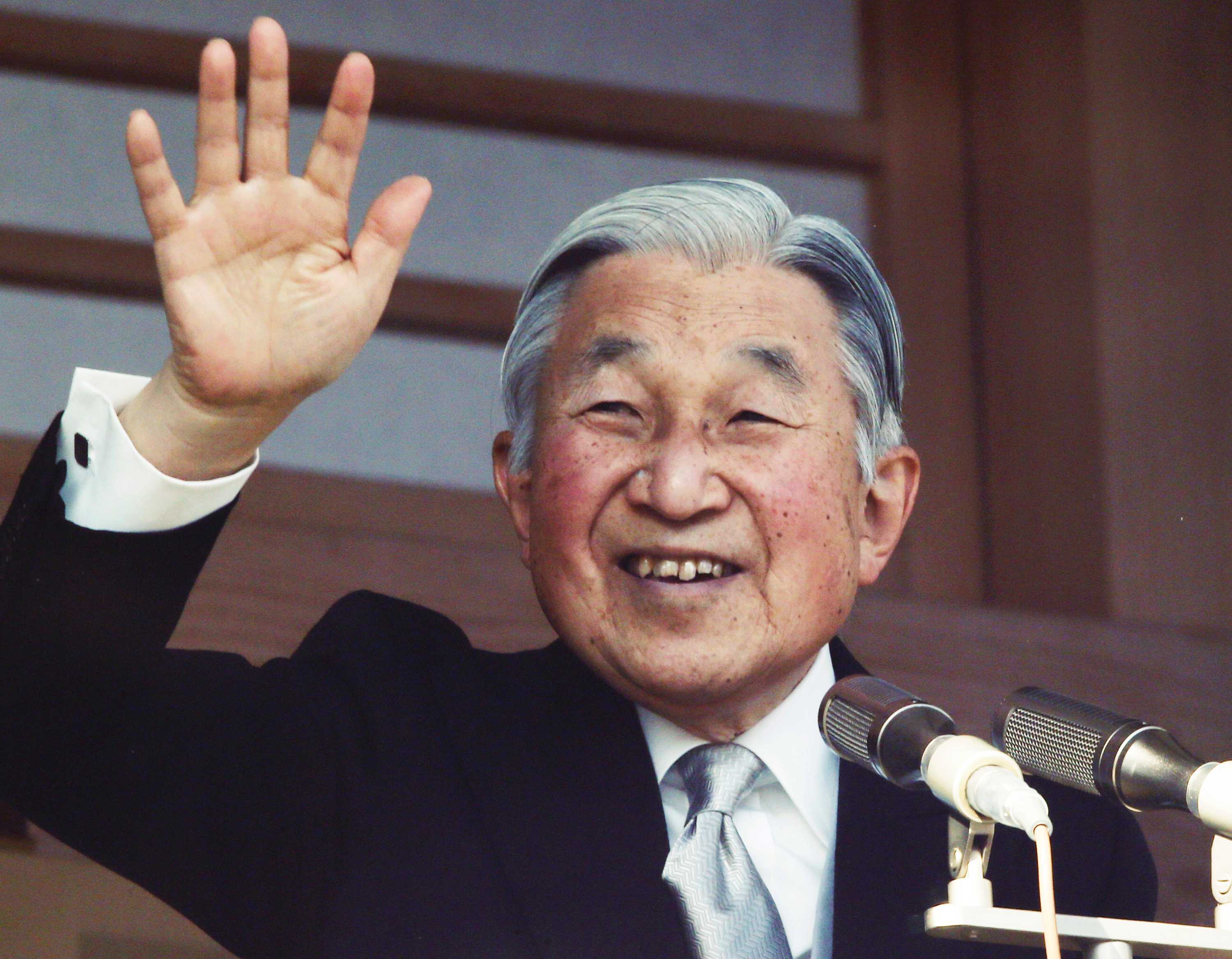 Japan's Emperor Akihito waves to well-wishers from a bullet-proofed balcony of the Imperial Palace in Tokyo.